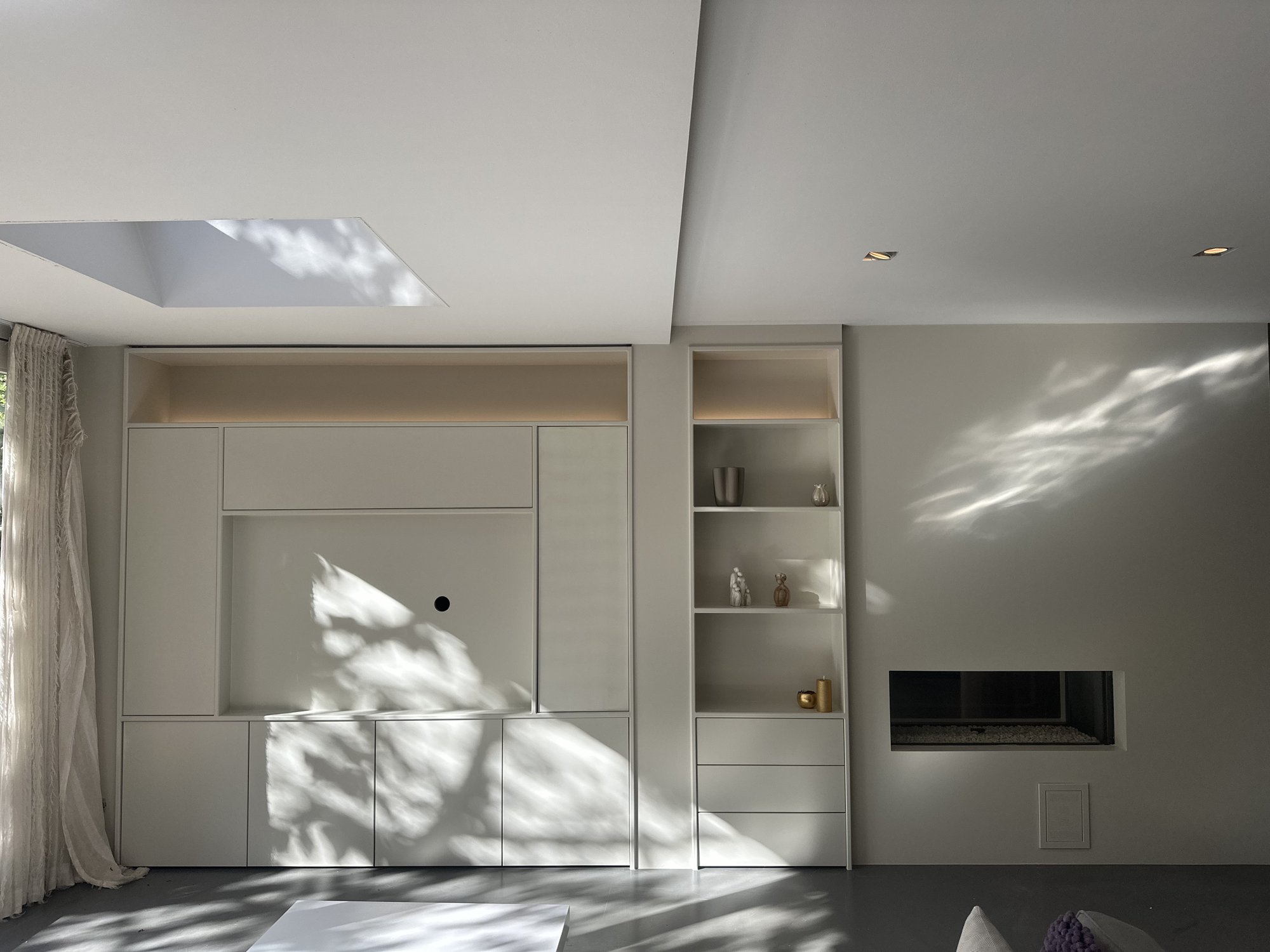 Witte maatwerk wandkast rond een haard in een woonkamer